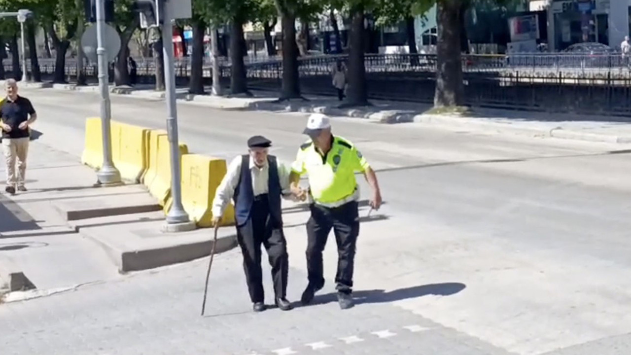 Trafik polisinin yürümekte zorlanan yaşlı adama yardımı yürekleri ısıttı